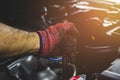 Hand of mechanic man with red glove has using socket wrench for repairing engine of a car in vehicle repair garage. Royalty Free Stock Photo