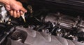 Hand of Mechanic technician service check level motor oil engine