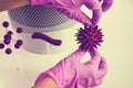 A hand in a medical glove holds the flu virus in the laboratory, concept. Search for a vaccine for coronavirus disease, white