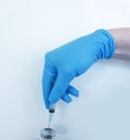 Hand in a medical glove holds a syringe, a bottle experiment