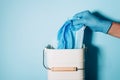 Hand in medical gloves throws medical mask into trash can on blue background. Quarantine over. Covid 19. Concept of coronavirus Royalty Free Stock Photo