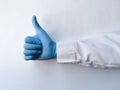 Hand of a medical worker shows thumb up on white isolated background. Hand gestures. Close-up of a hand showing thumb up