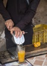 Hand of men is squeezing orange fruit using manual hand press juicer Royalty Free Stock Photo