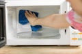 Hand with microfiber cleaning rag wiping inside of microwave oven, Royalty Free Stock Photo
