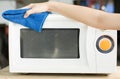 Hand with microfiber cleaning rag wiping inside of microwave oven, Royalty Free Stock Photo