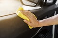 Hand with microfiber cloth cleaning interior car door Royalty Free Stock Photo