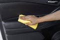 Hand with microfiber cloth cleaning interior car door Royalty Free Stock Photo