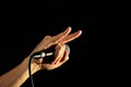 Hand with microphone and devil horns isolated on black Royalty Free Stock Photo