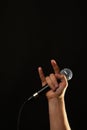 Hand with microphone and devil horns isolated on black Royalty Free Stock Photo