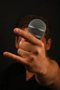 Hand with microphone and devil horns isolated on black Royalty Free Stock Photo