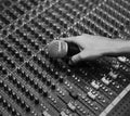 Hand with microphone on a sound mixer grayscale Royalty Free Stock Photo