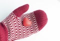 Hand in mitten holding red heart shape