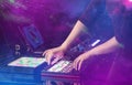 Hand mixing music on djcontroller with party club colors around Royalty Free Stock Photo
