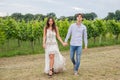Hand in hand, the model couple swagger through the vineyards in the countryside