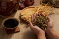 Hand model is holding Chinese motherwort with a bowl of medicine beside Royalty Free Stock Photo