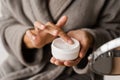 Hand moisturizer cream close-up. Hands cream for protect skin from dryness in bedroom. African american woman in Royalty Free Stock Photo