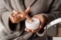 Hand moisturizer cream close-up. Hands cream for protect skin from dryness in bedroom. African american woman in Royalty Free Stock Photo