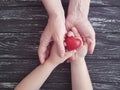 Hand mom and baby heart red symbol protection black wooden Royalty Free Stock Photo