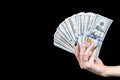 Hand with money isolated on black background. US Dollars in hand. Handful of money. Business woman offering money. Counting money.