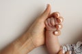 The hand of a mother and father close-up holds the fist of a newborn baby. Royalty Free Stock Photo