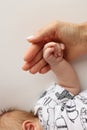 The hand of a mother and father close-up holds the fist of a newborn baby. Royalty Free Stock Photo