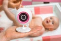 Mother is holding baby monitor camera for safety of her baby Royalty Free Stock Photo