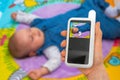 Mother is holding baby monitor camera for safety of her baby Royalty Free Stock Photo