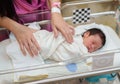 Hand of mother putting newborn baby to sleep in the infant bassinet basket at hospital Royalty Free Stock Photo