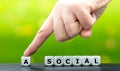 Hand moves a dice and changes the word `asocial` to `social`.