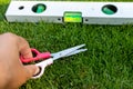 The hand mower cutting the grass using scissors and leveling tool