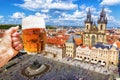 Hand with a mug of beer on the background of the Old Town Square Royalty Free Stock Photo