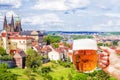 Hand with a mug of beer on the background of the panorama of Prague