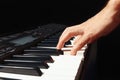 Hand of musician play the keys of the digital piano on black background Royalty Free Stock Photo