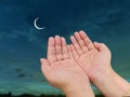Hand of Muslim women praying with sky moon background.