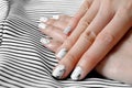 Hand and Nail Polish, Manicure Nail. Close Up Granite Gray Nails with Black and White Fabric Background