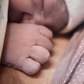 Hand of a newborn baby close-up. Laying the child out on the mother chest immediately after childbirth. A woman who gave birth to Royalty Free Stock Photo