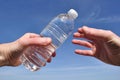 Hand Offering a Bottle of Water Royalty Free Stock Photo