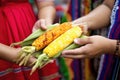 hand offering elote to another hand