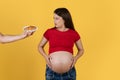 Hand Offering Plate With Croissant To Confused Pregnant Woman