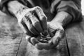 Hand old man begging for money because of the hunger on the wood table. vintage tone Royalty Free Stock Photo