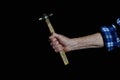 hand of an old man holding vintage hammer with wooden handle isolated on black background Royalty Free Stock Photo