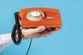 Hand with old rotary telephone over blue background Royalty Free Stock Photo