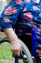 Hand of the old woman on an invalid armchair