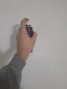 A hand olding a spray can against a wall