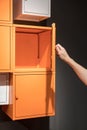 Hand open the orange metal cabinets hanging on black wall Royalty Free Stock Photo