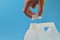 Hand opened white gallon bottle cap isolated on a blue background Royalty Free Stock Photo