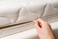 Hand opening cover of new mattress with zipper. Changing and washing cover. Front view. Close up Royalty Free Stock Photo