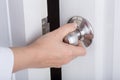 Hand opening door knob on white door Royalty Free Stock Photo