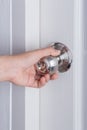 Hand opening door knob on white door Royalty Free Stock Photo