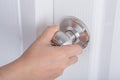 Hand opening door knob on white door Royalty Free Stock Photo